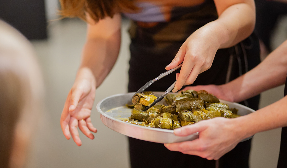 Gillian Kayrooz serving her dish, dolmades, at A Shared Table event