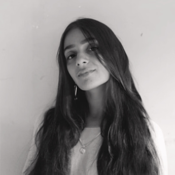 A black and white photograph of a woman with brown hair wearing a white shirt.